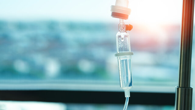 Close Up Saline Solution Drip For Patient And Infusion Pump In Hospital, With Space And Bright Background.