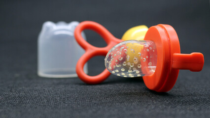 Orange baby pacifier with lid