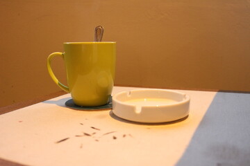 Elegant cup and ashtray with cigarettes