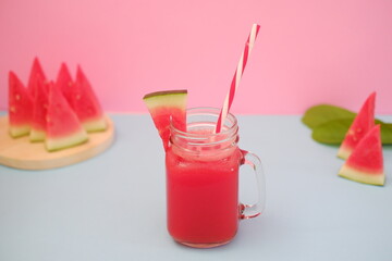 Watermelon smoothie in a glass jar with straws as a background