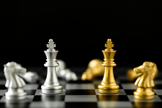 Golden and Silver King chess standing in front of other chess on chess board.