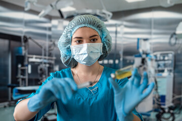 Fototapeta na wymiar nurse in mask and gloves holding a syringe with medicine and waiting for a patient in surgery.