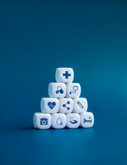 Healthcare medical, wellness plan and insurance concept. Health, care, hospital service and medical element icon symbols on clean white blocks stacking arranged pyramid shape on blue background.