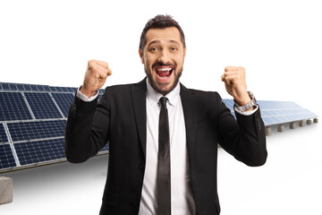 Young businessman gesturing happiness at a solar farm