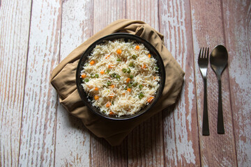 Indian style vegetable pulav or biryani made with basmati rice and served in a bowl. Close up, selective focus.