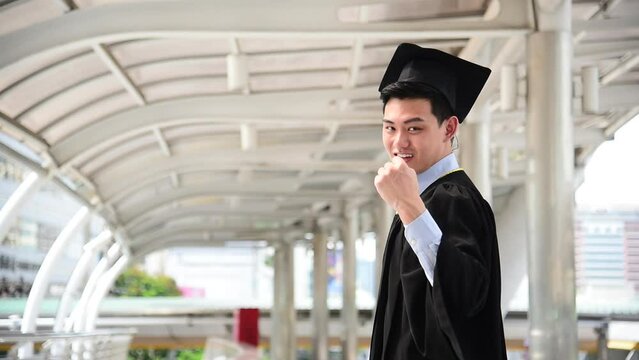Portrait happy asian man graduate student smile face wear gown, hat with arm cross. Young man smile happy face looking at camera. Proud male college graduate bachelor confidence student college