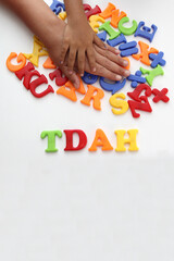 Hands of mom and daughter playing with colored letters that form ADHD Attention Deficit...