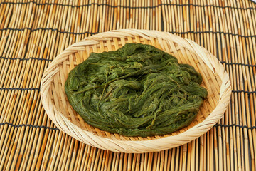 Spirogyra Korean seaweed alga fulvescens or Maesaengi in wood plate on table or bamboo mat background. Spirogyra Korean seaweed alga fulvescens or Maesaengi. seaweed alga fulvescens Spirogyra food