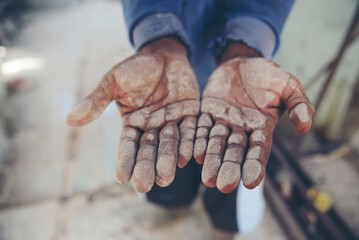 Close Up of dirty stained palm hand, cement dust and black lubricant oil in construction site. Worker's hand concept.