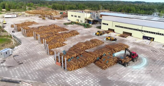 Modern equipment at the timber factory. Modern technology at the sawmill. Auto with a manipulator arm loads logs.