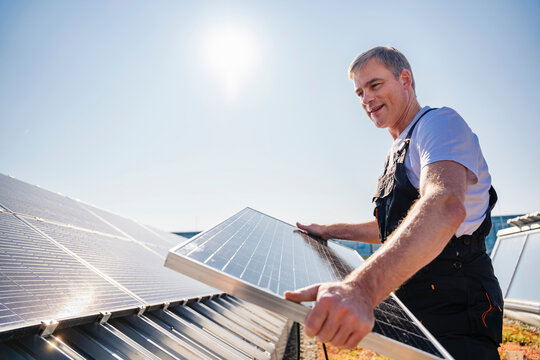 Craftsman installing solar panels on the roof of a company building