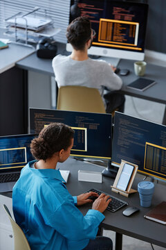 IT professionals working on desktop computers at desks