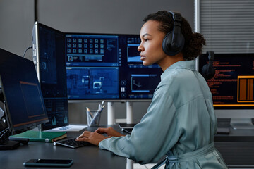 Young computer programmer coding and working on desktop PC at desk