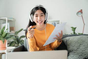 Asian girl work using laptop, online learn video conference with headphones - 637247859