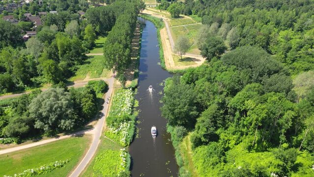 Aerial drone shot above a nature park, water canal with boats,  of Almere city, province Flevoland, Netherlands
