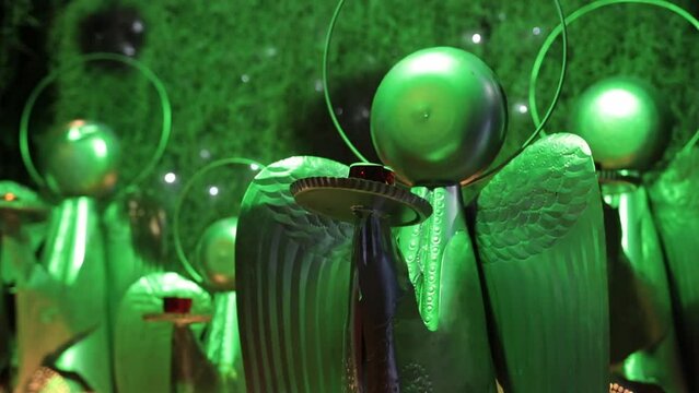 Hand-held shot of homemade Christmas angel ornaments for sale under lef lights