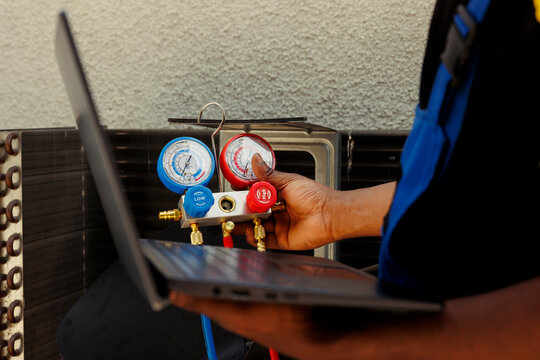 Seasoned mechanic restoring cooling capacity of air conditioning system by removing existing refrigerant, inspecting system for leaks and recharging with new freon to prevent damage to compressor