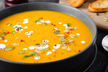 Pumpkin Soup, Tasty Homemade Pumpkin, Sweet Potato, Carrot Soup in a Bowl on Dark Background