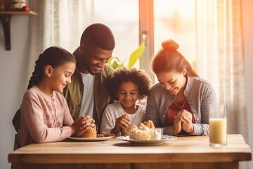 Obraz na płótnie Canvas Happy multiracial family couple with children pray together before having morning breakfast at home together. Multiethnic parents with mixed race kids hold hands say prayer sit at kitchen table