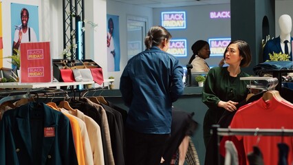 Diverse people rushing to pick clothes on black friday big sales event, running around clothing...