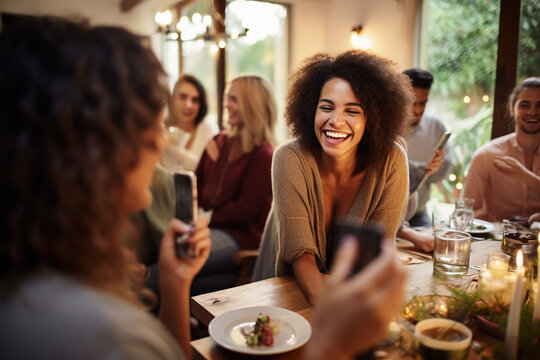 Woman taking picture of her friends at dinner party