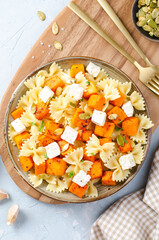 Pasta with Roasted Pumpkin, Farfalle Pasta with Pumpkin and Feta on a Plate on Bright Background