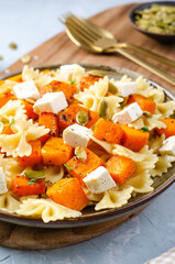 Pasta with Roasted Pumpkin, Farfalle Pasta with Pumpkin and Feta on a Plate on Bright Background