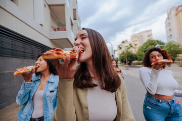 Group of friends enjoying pizza on the streets