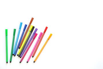 Markers of different colors on a white background, top view.