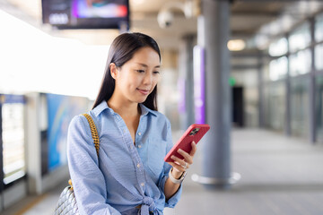 Woman use mobile phone in train station