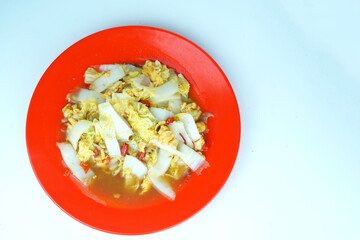 Sauted white mustard greens with scrambled eggs served on a white plate
