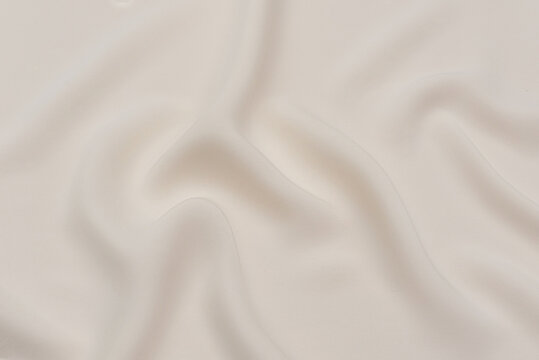 Close-up texture of natural beige or ivory or white color fabric. Fabric texture of natural silk satin or cotton textile material. Light canvas background.