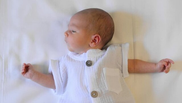 Portrait of cute newborn baby close-up. Newborn lies and waves his arms.