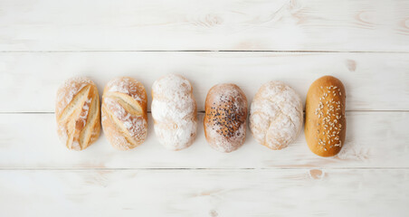 Set of fresh buns, small round artisan bread on wooden table background, minimal style aesthetic top view, trend hand made gluten free sourdough bread from whole grain flour, generative ai