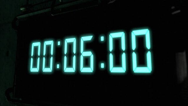 High quality CGI render of a digital countdown timer on a wall-mounted screen, with glowing pale blue numbers, counting down from 10 to zero, with dramatic right to left camera move