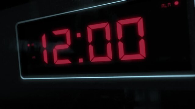 High quality CGI render of a digital alarm clock, with glowing red numbers, ticking over from 11.59 to 12.00 a.m. with dramatic right to left camera move - witching hour