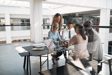 Diverse businesspeople smiling during a meeting in an office lounge