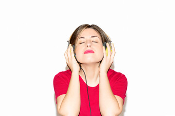 Naklejka premium Woman listening to music on a white background.