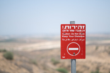 A bright red warning sign outside of the Gaza Strip, near the separation fence around the...