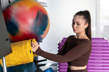 a young woman in fitness gym changing the weight bar dumbbell
