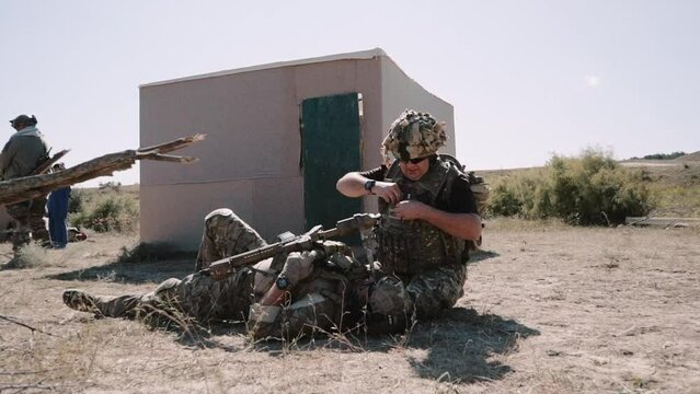 in the war. an armed soldier assists a wounded soldier