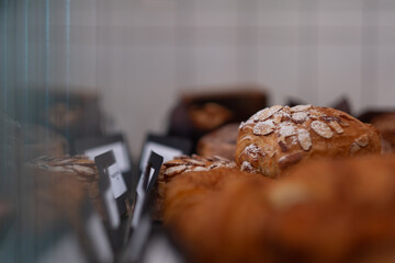Freshly baked goods for sale at a coffee shop. Rows of scones, croissants, and other goods are displayed in a glass case.