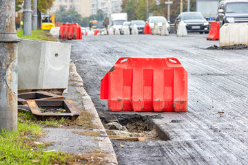 Replacement of old storm sewer hatches on the side of the carriageway of a city road. - obrazy, fototapety, plakaty