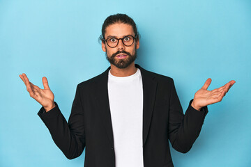 Businessman in suit with eyeglasses and beard surprised and shocked.