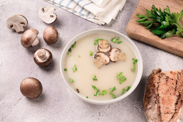 Homemade mushroom soup in a bowl on a gray background.