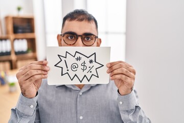 Middle east man with beard holding banner with swear words making fish face with mouth and squinting eyes, crazy and comical.