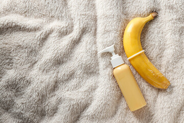 Condom on banana with lubricant on light background, place for text