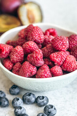 Bowl with raspberries on the kitchen table, close-up.