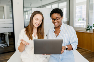 Good cooperation and friendly office atmosphere. Two female colleague discussing project on the...