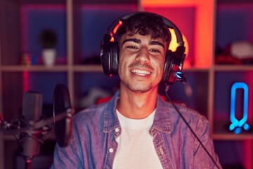 Young hispanic man playing video games with a happy and cool smile on face. lucky person.